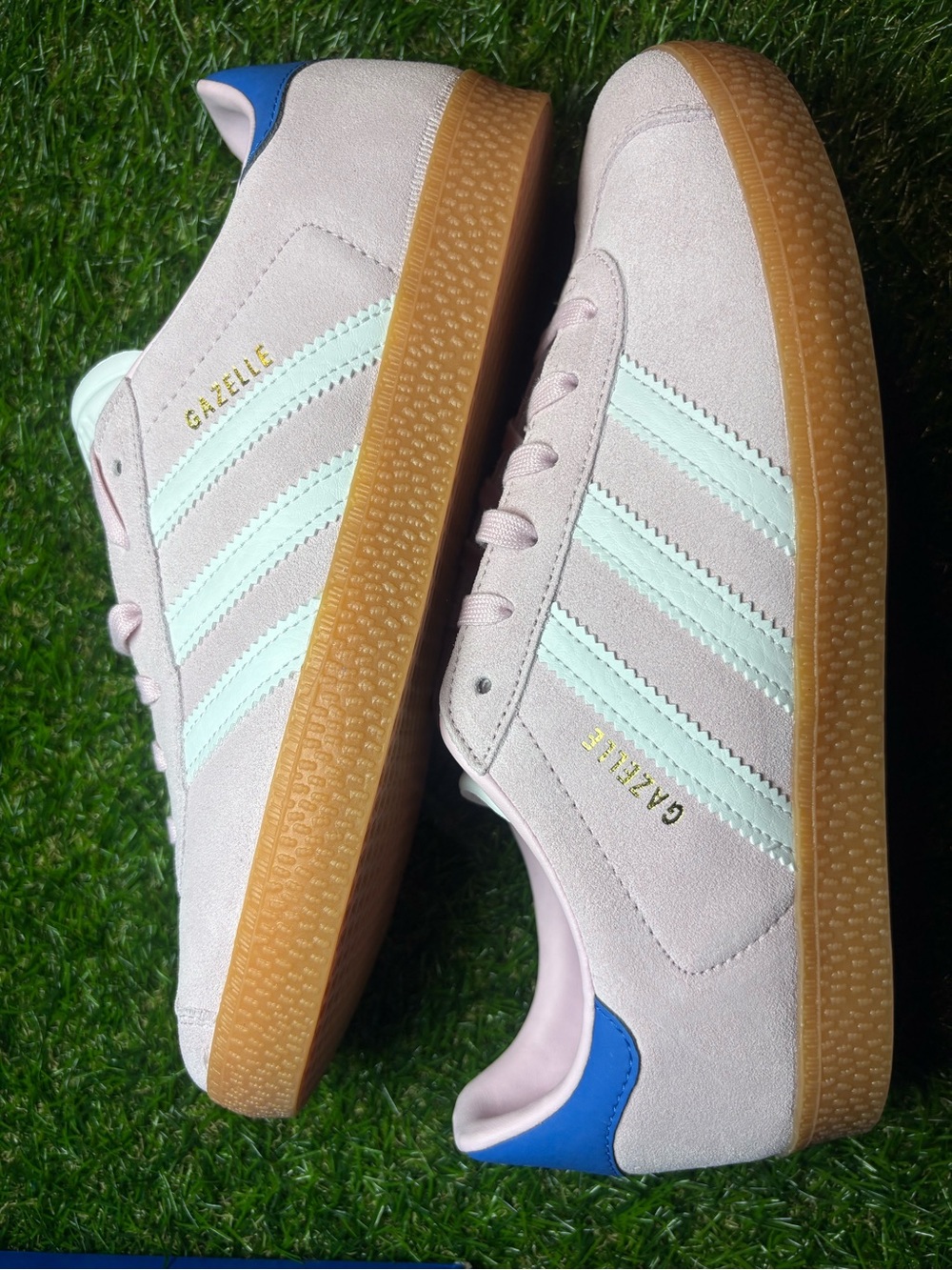 Adidas Gazelle Suede Sneakers in Light Pink with white Stripes and a blue heel.